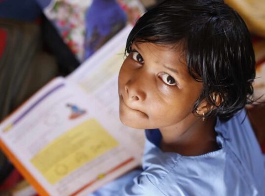 A female student in a village looks with hopeful eyes.